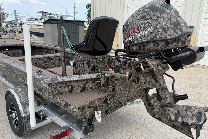 Slide: The Image of 2026 Pro-Drive 2054 X TD Stick Steer boat with camouflage design on trailer. - 10