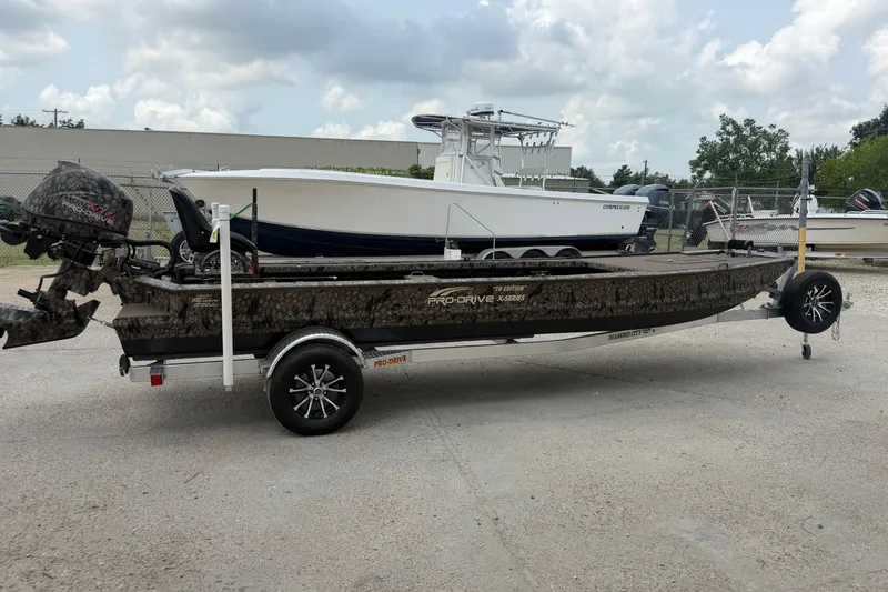 Slide: The Image of 2026 Pro-Drive 2054 X TD Stick Steer boat on trailer, parked outdoors. - 4
