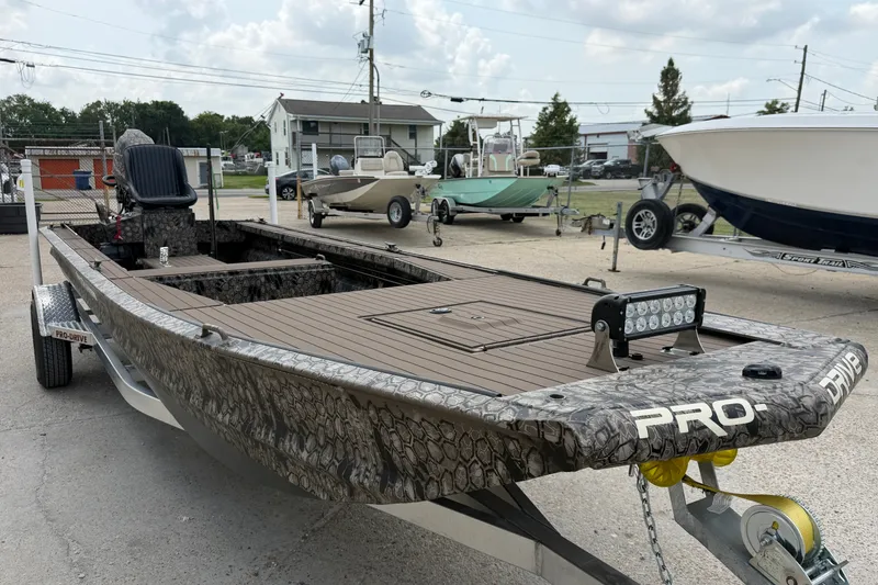 Slide: The Image of 2026 Pro-Drive 2054 X TD Stick Steer boat with camouflage design on a trailer. - 6