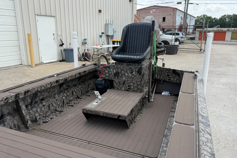 Slide: The Image of 2026 Pro-Drive 2054 X TD Stick Steer boat with camouflage interior, parked outside a building. - 8