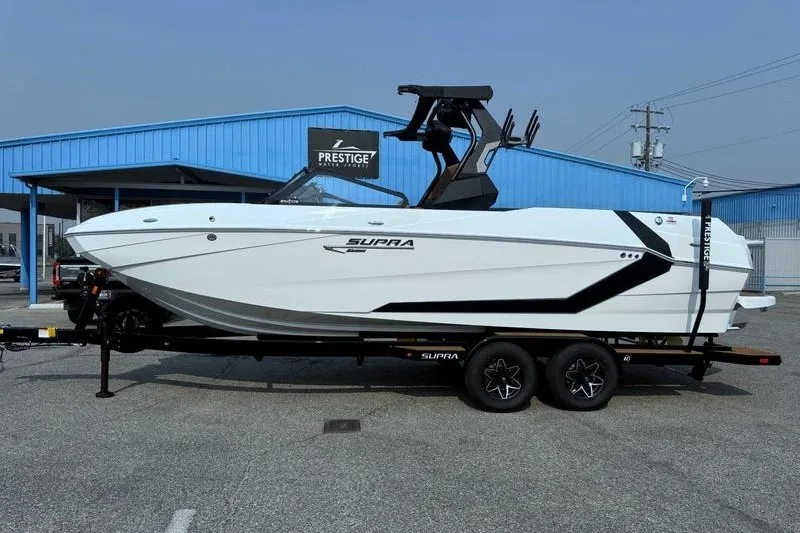 The Image of 2027 Supra SR boat on trailer at dealership, showcasing sleek design and modern features. - 1
