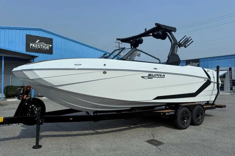 Slide: The Image of 2027 Supra SR boat on trailer at Prestige Water Sports dealership. - 3