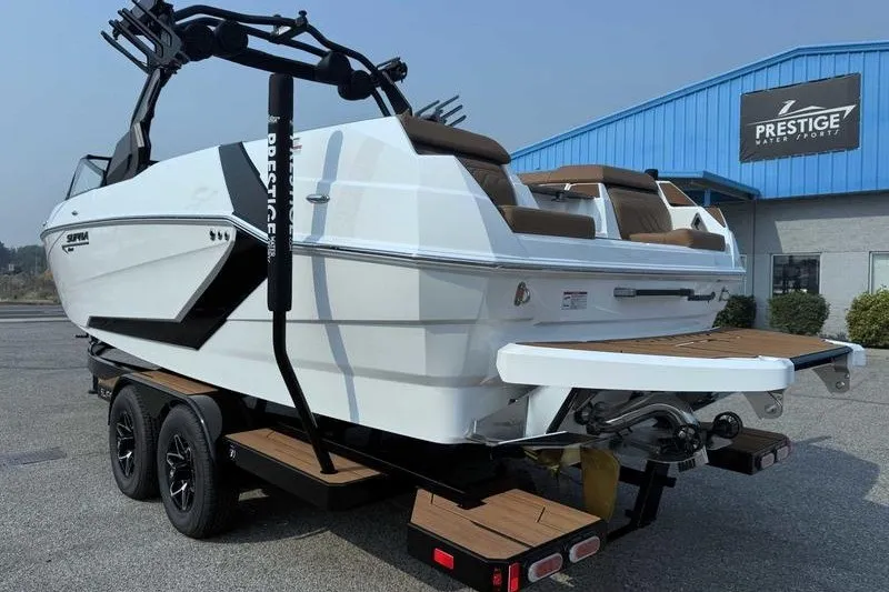 Slide: The Image of 2027 Supra SR boat on trailer at Prestige Water Sports dealership. - 11