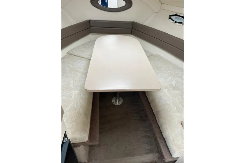 Slide: The Image of Interior cabin of 2000 Larson Cabrio 254 boat with table and cushioned seating. - 4