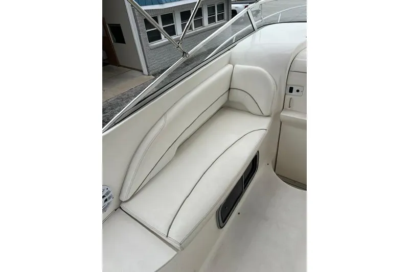 Slide: The Image of 2000 Larson Cabrio 254 boat interior with white leather seating and sleek design. - 13