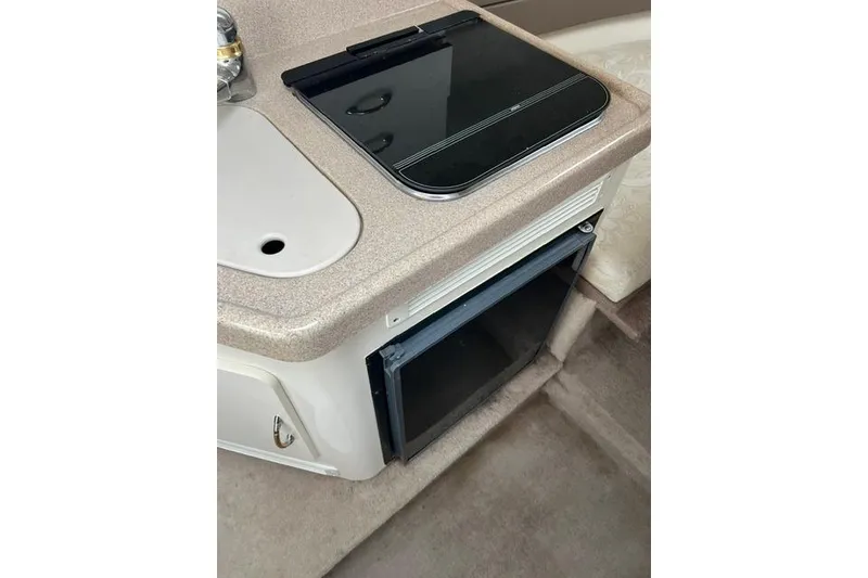 Slide: The Image of 2000 Larson Cabrio 254 interior kitchenette with stove and mini-fridge. - 5