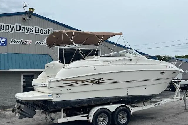 Slide: The Image of 2000 Larson Cabrio 254 boat on trailer at Happy Days Boating dealership. - 1