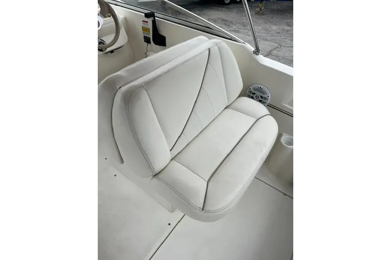 Slide: The Image of White leather seat on 2000 Larson Cabrio 254 boat, featuring sleek design and comfort. - 12