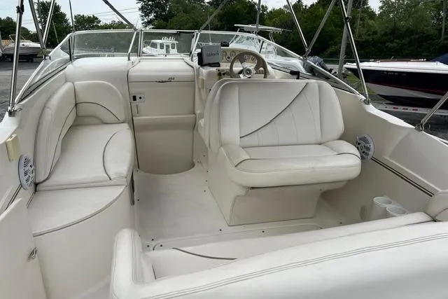 Slide: The Image of 2000 Larson Cabrio 254 boat interior with white seating and steering console. - 14