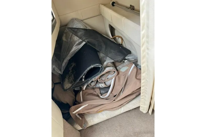 Slide: The Image of Interior storage area of a 2000 Larson Cabrio 254 boat with various items. - 6