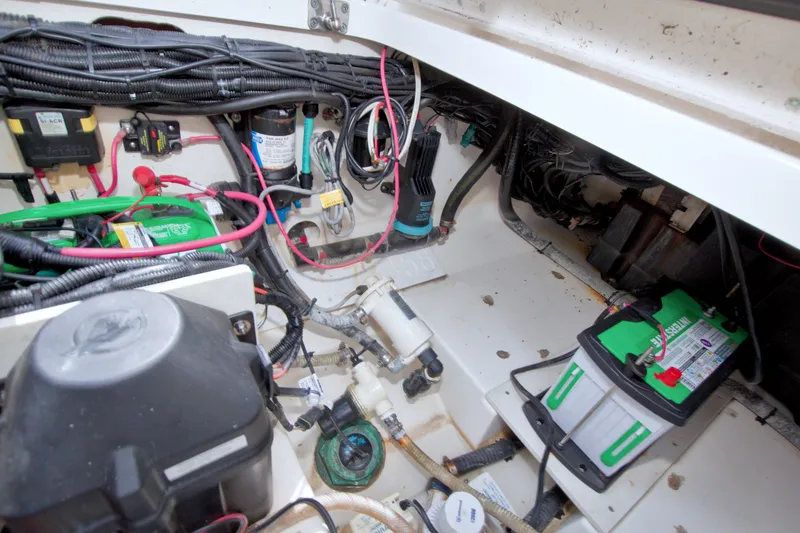 Slide: The Image of Engine compartment of a 2017 Boston Whaler 320 Vantage with visible wiring and batteries. - 58
