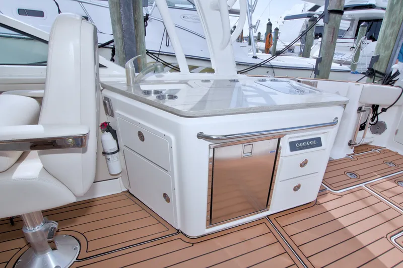 Slide: The Image of 2017 Boston Whaler 320 Vantage boat interior with kitchenette and seating area. - 51