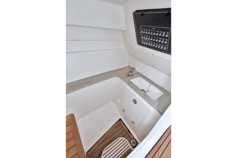 Slide: The Image of Interior of 2017 Boston Whaler 320 Vantage boat, featuring a compact sink and control panel. - 39