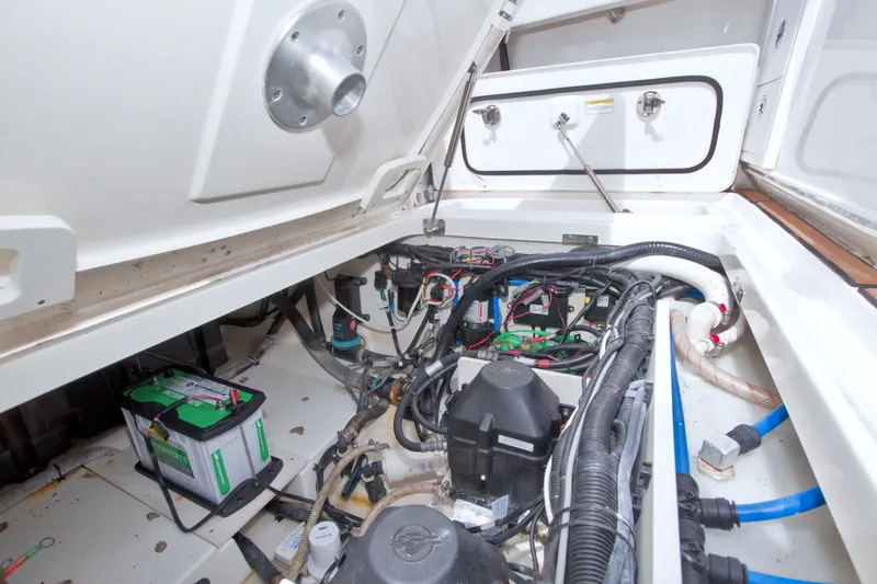 Slide: The Image of Engine compartment of a 2017 Boston Whaler 320 Vantage, showcasing wiring and battery setup. - 56