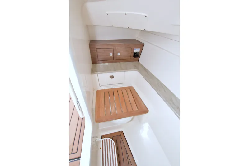 Slide: The Image of Interior of 2017 Boston Whaler 320 Vantage boat, featuring wooden accents and storage compartments. - 41