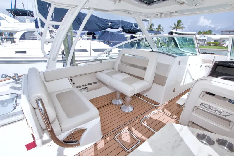 Slide: The Image of 2017 Boston Whaler 320 Vantage boat interior with white seating and wooden deck. - 28