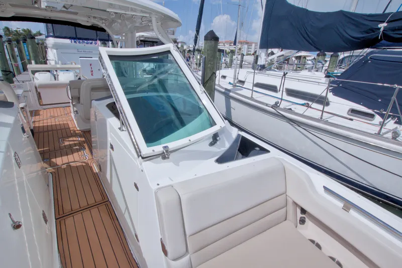 Slide: The Image of 2017 Boston Whaler 320 Vantage boat interior with teak flooring and seating at marina. - 49