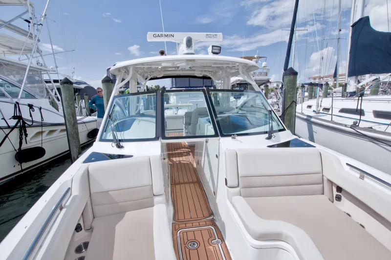 Slide: The Image of 2017 Boston Whaler 320 Vantage boat docked, featuring spacious seating and Garmin equipment. - 48