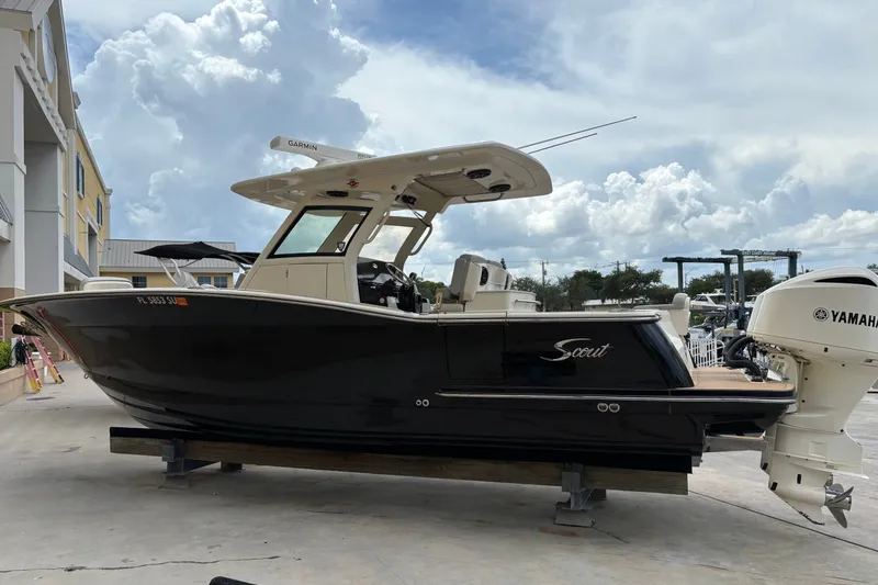 The Image of 2021 Scout 305 LXF boat with Yamaha engine, docked under cloudy sky. - 0