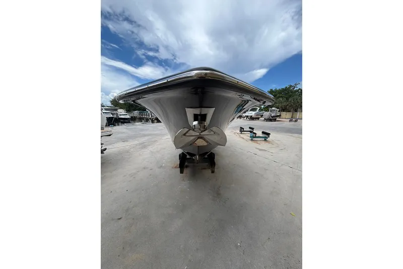 Slide: The Image of 2021 Scout 305 LXF boat on dry dock under a cloudy sky. - 13