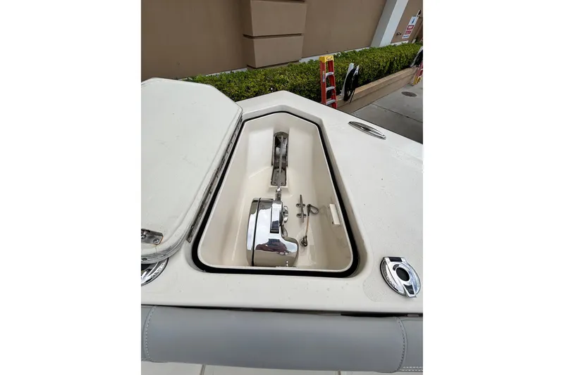 Slide: The Image of 2021 Scout 305 LXF boat anchor compartment with open hatch, showcasing stainless steel fittings. - 27