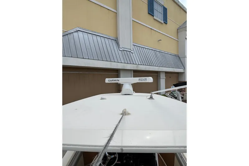 Slide: The Image of 2021 Scout 305 LXF boat with Garmin radar, docked near a building. - 38