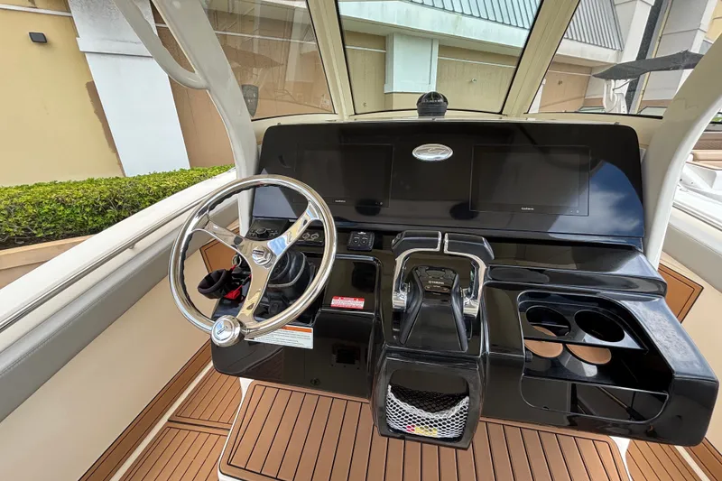 Slide: The Image of 2021 Scout 305 LXF boat dashboard with steering wheel and dual screens. - 34