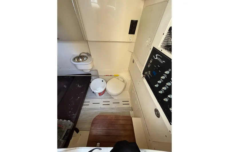Slide: The Image of Interior of 2021 Scout 305 LXF boat featuring sink, control panel, and storage area. - 37