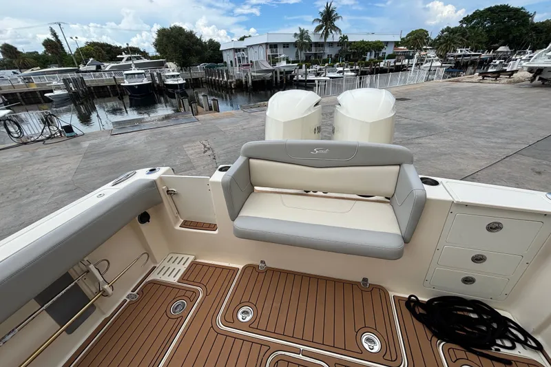Slide: The Image of 2021 Scout 305 LXF boat interior with seating and deck, docked at marina. - 17
