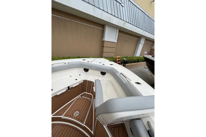 Slide: The Image of 2021 Scout 305 LXF boat interior with cushioned seating and teak flooring. - 25