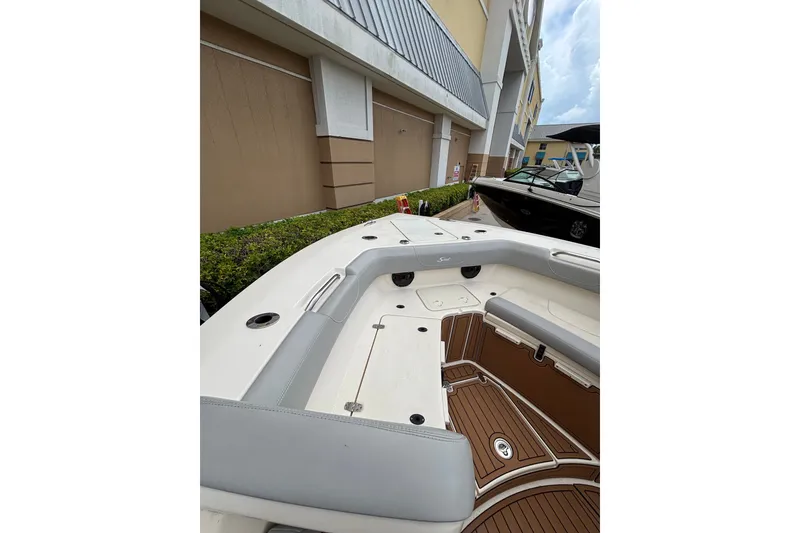 Slide: The Image of 2021 Scout 305 LXF boat interior with cushioned seating and teak flooring. - 26