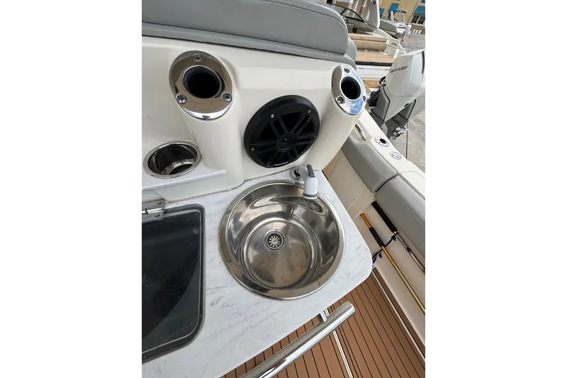 Slide: The Image of 2021 Scout 305 LXF boat interior with sink and cup holders. - 20