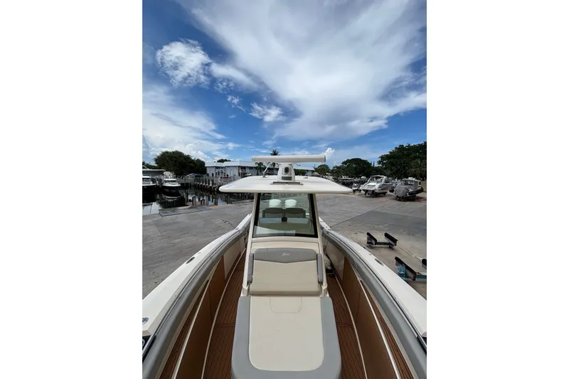 Slide: The Image of 2021 Scout 305 LXF boat docked under a partly cloudy sky. - 28