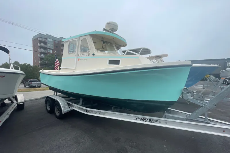 The Image of 1996 Rosborough Seaskiff 22 Wheelhouse Inboard on trailer, light blue hull, parked outdoors. - 1