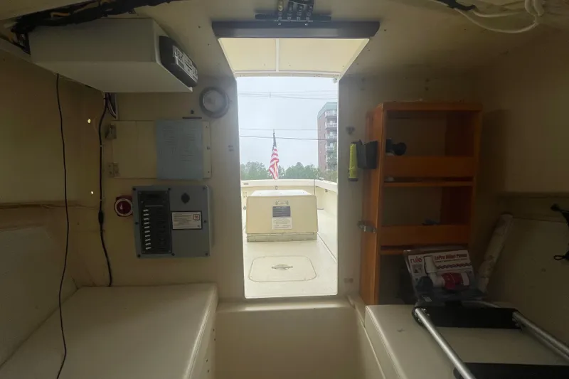 Slide: The Image of Interior view of a 1996 Rosborough Seaskiff 22 Wheelhouse Inboard boat, featuring control panels and storage. - 12