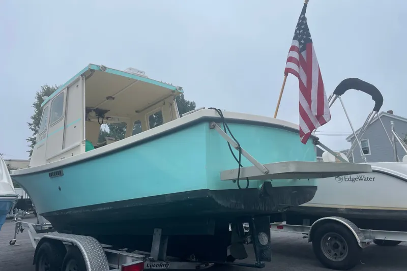 Slide: The Image of 1996 Rosborough Seaskiff 22 Wheelhouse Inboard boat on trailer with American flag. - 6