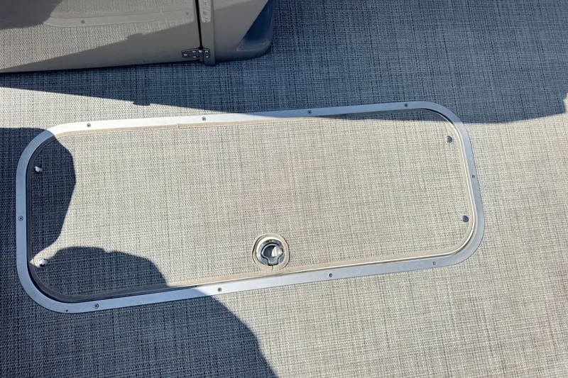 Slide: The Image of 2023 South Bay S224RS boat floor hatch with textured surface and metal frame. - 6
