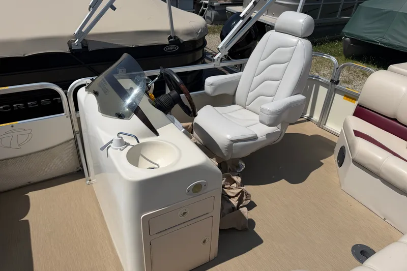 Slide: The Image of 2005 Tahoe Pontoon Sierra 20' boat interior with captain's chair and steering console. - 7