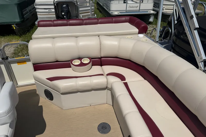 Slide: The Image of 2005 Tahoe Pontoon Sierra 20' boat interior with beige and maroon seating, cup holders. - 13
