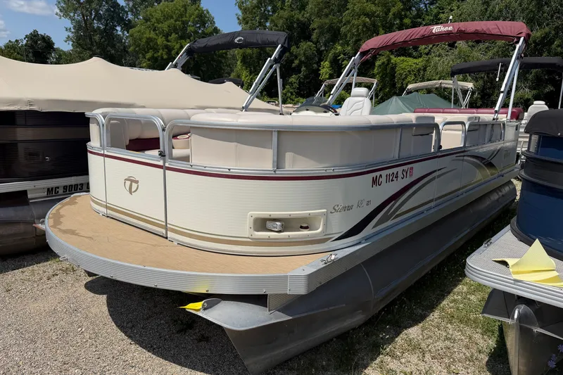 The Image of 2005 Tahoe Pontoon Sierra 20' boat with maroon accents, parked on gravel. - 0