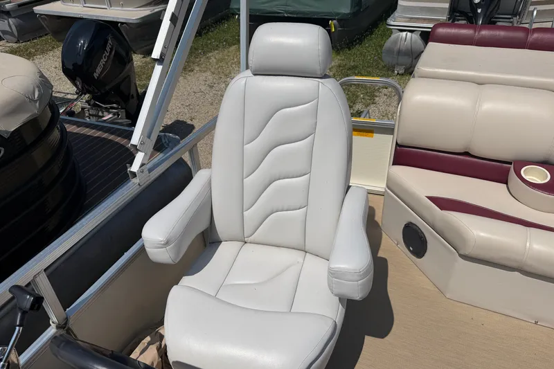 Slide: The Image of 2005 Tahoe Pontoon Sierra 20' boat interior with white captain's chair and seating. - 11