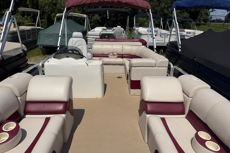 Slide: The Image of 2005 Tahoe Pontoon Sierra 20' boat with spacious seating and cup holders, docked outdoors. - 2