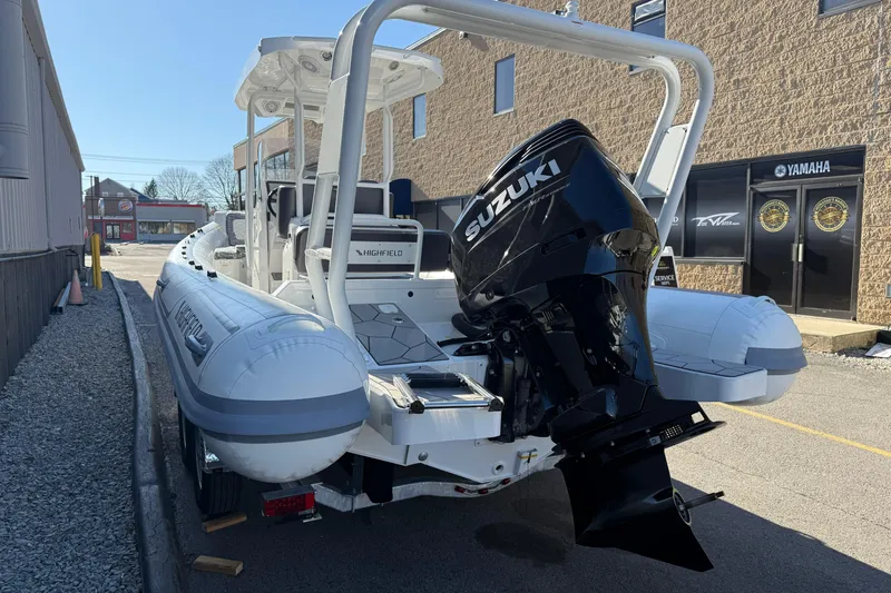 Slide: The Image of 2026 Highfield Sport 760 boat with Suzuki outboard motor, parked outdoors. - 8