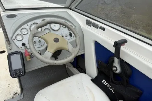 Slide: The Image of 2004 Bayliner 194 boat cockpit with steering wheel, control panel, and throttle lever. - 8