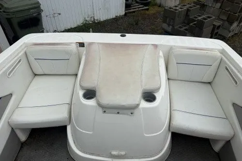 Slide: The Image of 2004 Bayliner 194 boat interior with white seating and cup holders. - 5