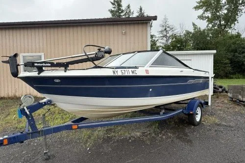 The Image of 2004 Bayliner 194 boat on trailer, parked outdoors near a building. - 1