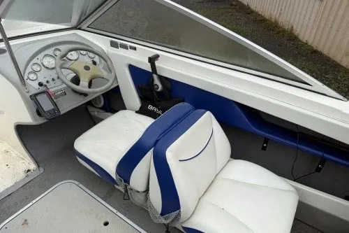 Slide: The Image of 2004 Bayliner 194 boat interior with white and blue seating and dashboard controls. - 6