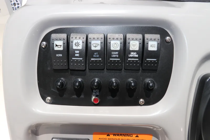 Slide: The Image of Control panel of 2027 Robalo R207 Dual Console boat with labeled switches. - 28