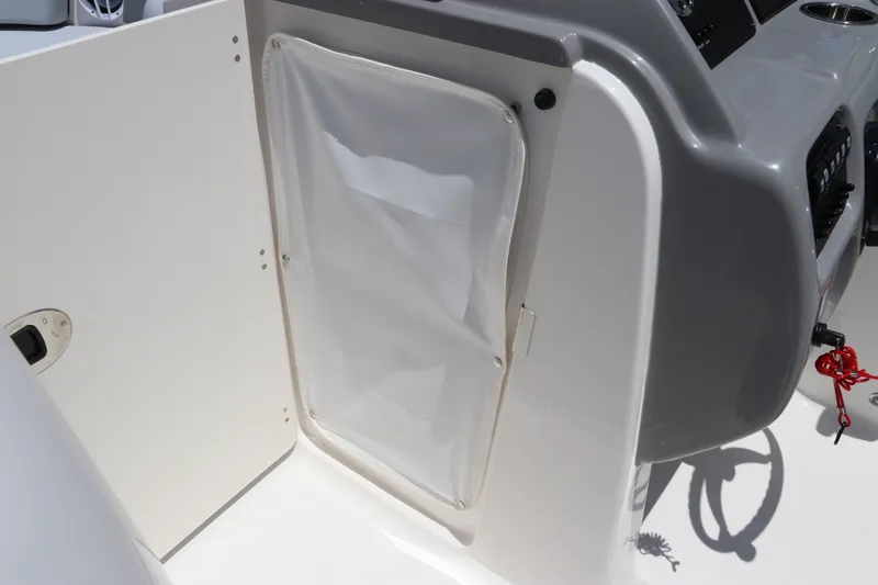 Slide: The Image of 2027 Robalo R207 Dual Console boat interior with storage compartment and control panel. - 32