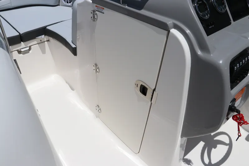Slide: The Image of 2027 Robalo R207 Dual Console boat interior with storage compartment and seating area. - 31